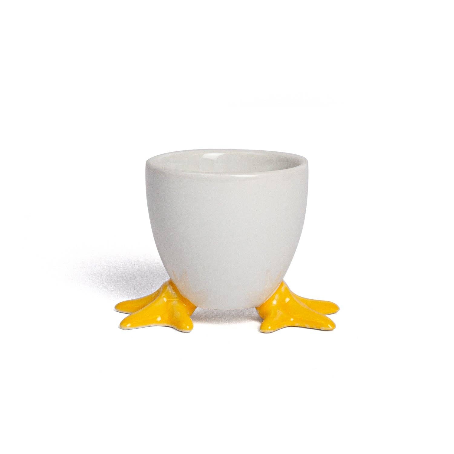 White ceramic egg cup with yellow feet on a white background