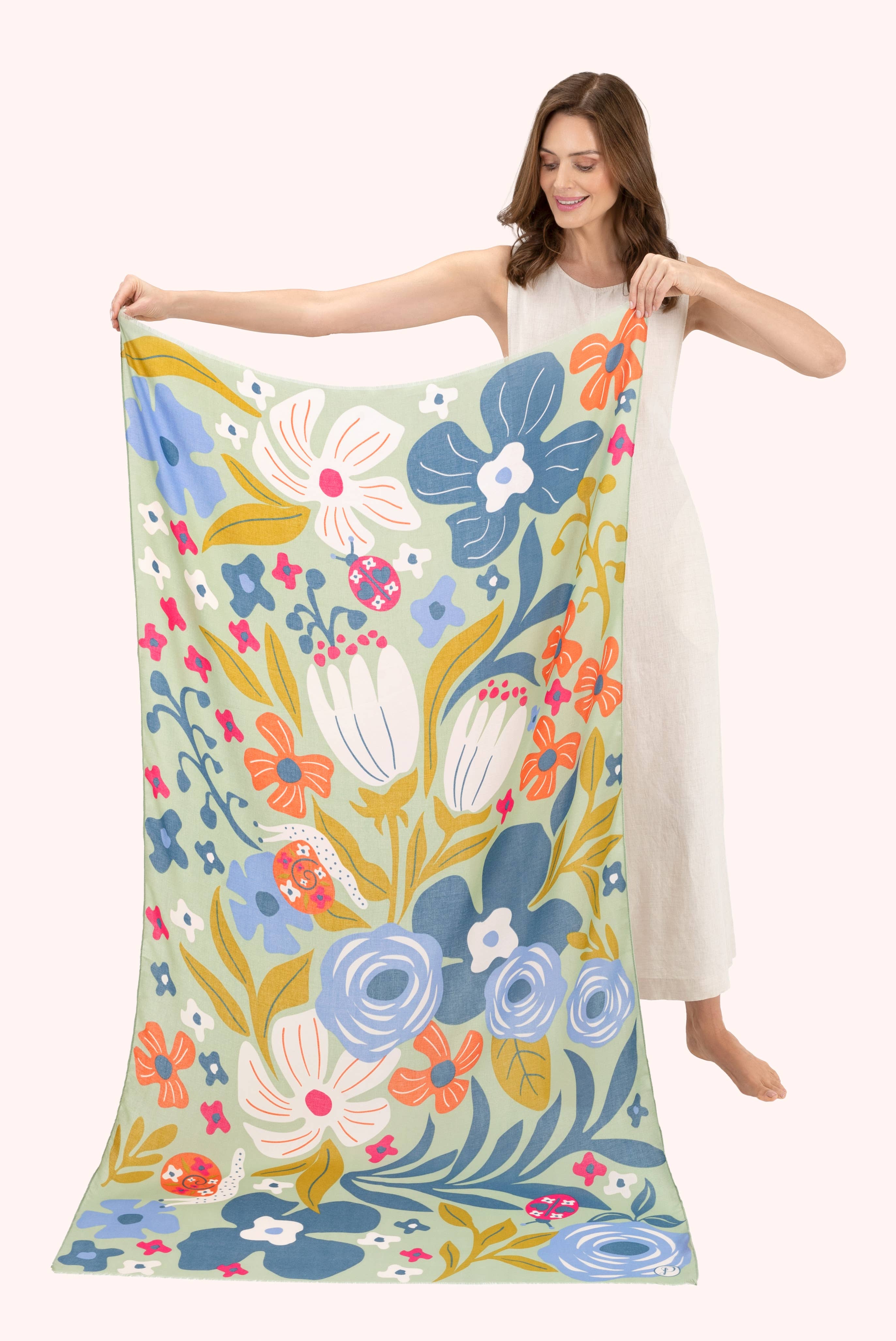 Woman holding a large floral-patterned fabric with colorful flowers on a white background