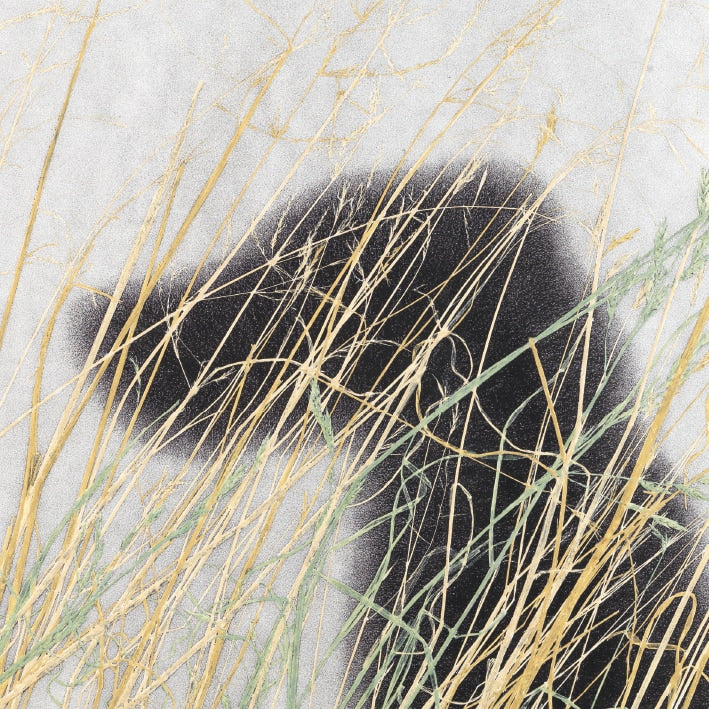 painting of the silhouette of a dog with yellow straw in the foreground on a pale grey background
