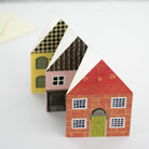 Three small house-shaped boxes with different designs on a white background