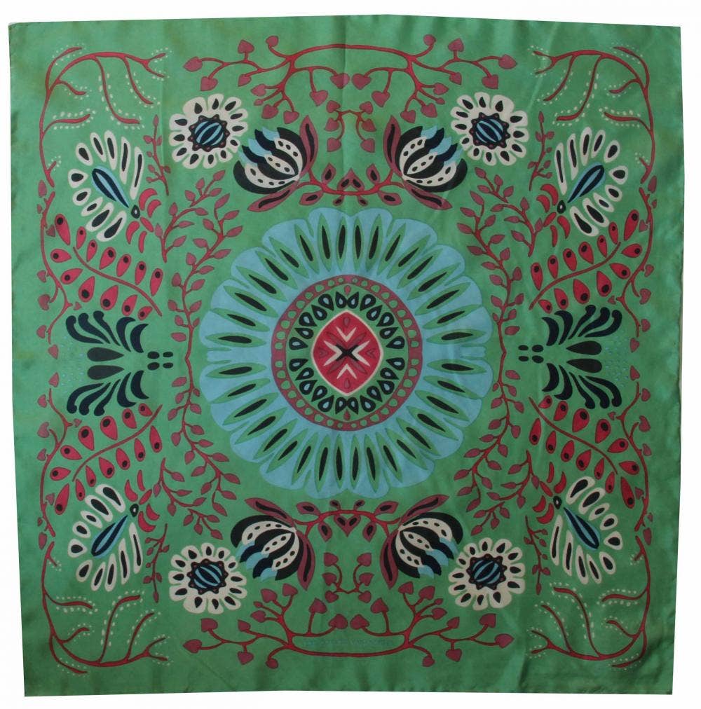 Decorative fabric with a central floral design on a green background