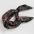 Green patterned scarf tied in a knot on a white background