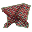 A square silk scarf with a green base, featuring a repeating red and blue floral pattern and a matching green border, laid out on a white background.