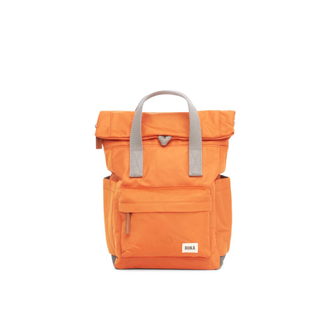 Photo showing the front of a small orange coloured backpack. There is a large pocket on the front with a brown zip pull, and the handles are grey.