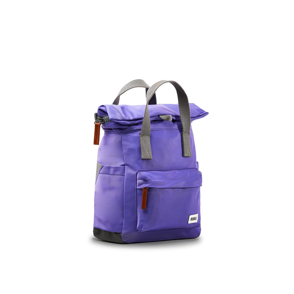 Photo showing the front and side of a small purple backpack. There is a large pocket on the front with a brown zip pull, and the handles are grey.
