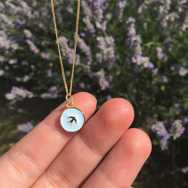 swallow enamel necklace in hand for size