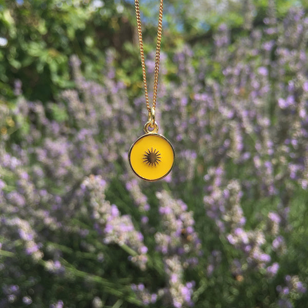 yellow enamel pendant in sun motif 