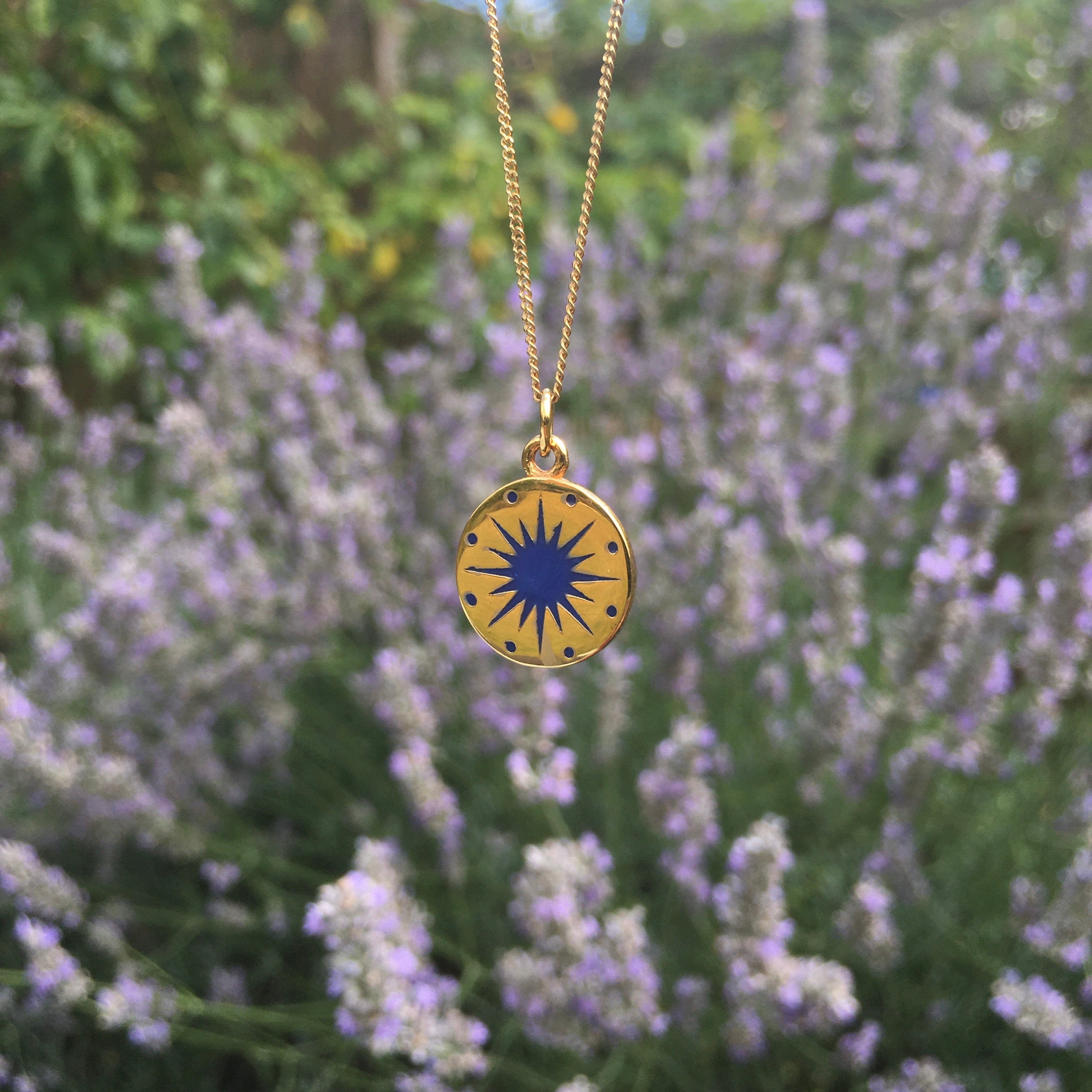 midnight blue enamel necklace in front of lavender plants 