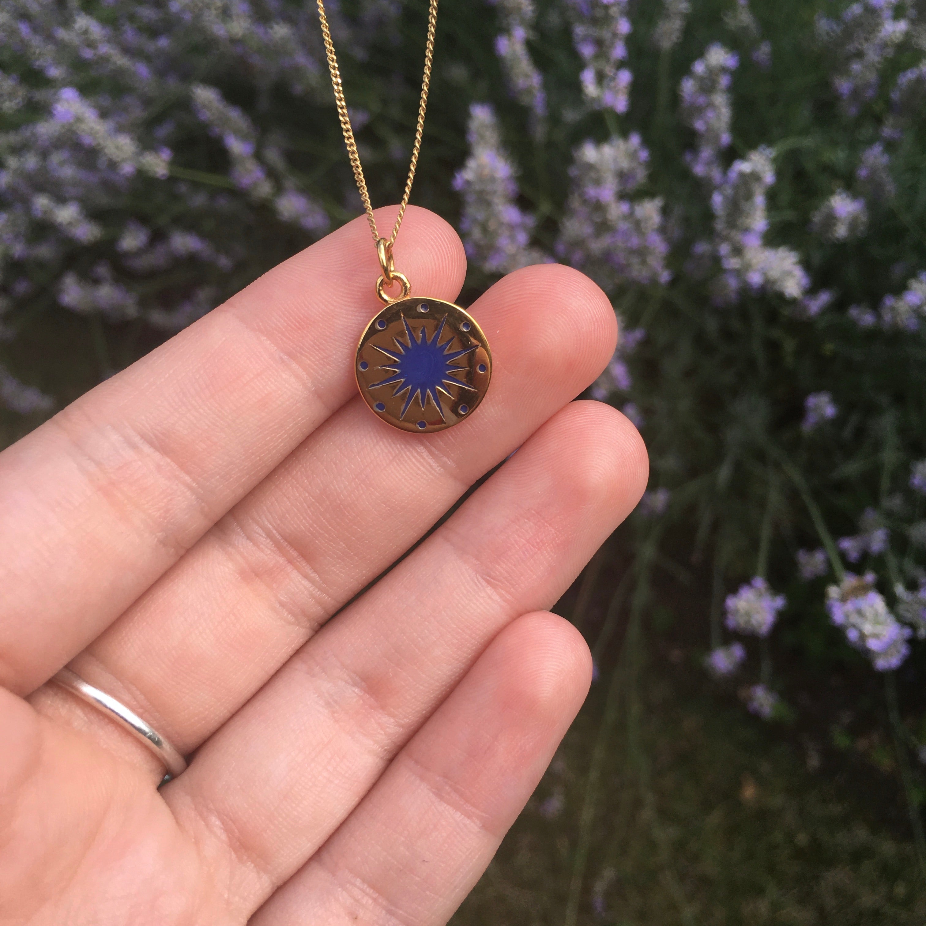 midnight blue enamel star necklace on hand to show size 