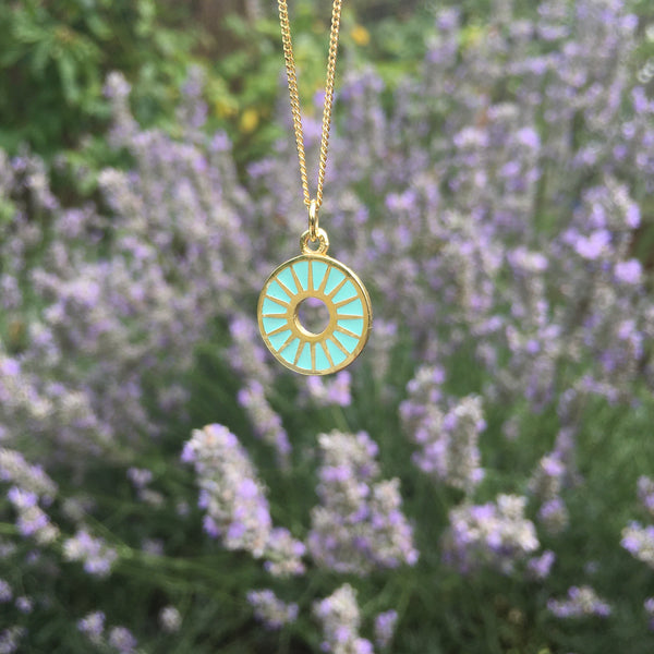 sunburst necklace in gold vermeil in front of lavender plants 