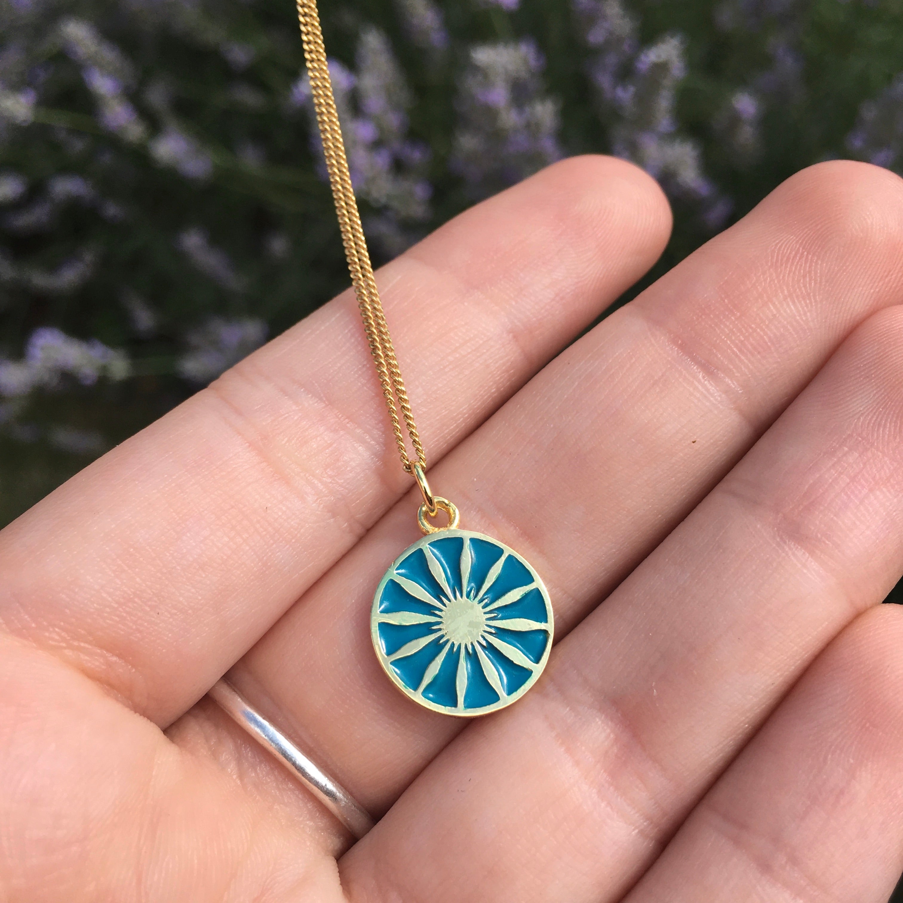 turquoise enamel pendant on hand to show size