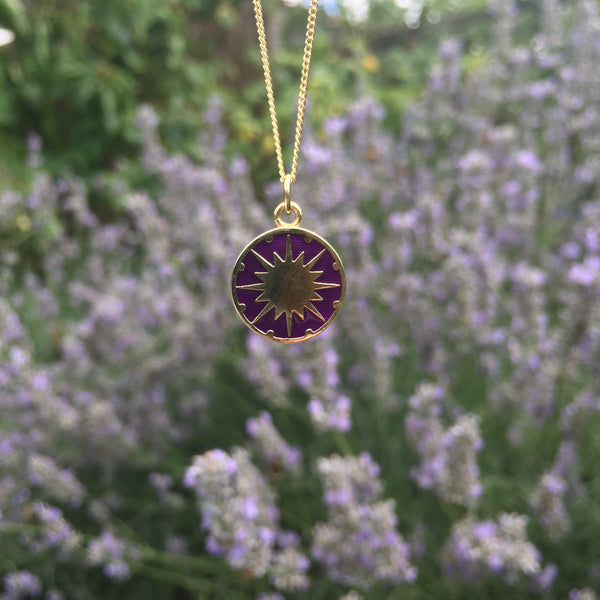 supernova enamel necklace in front of lavender