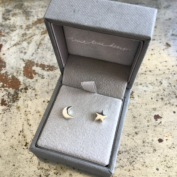 A simple pair of sterling silver moon and star stud earrings.