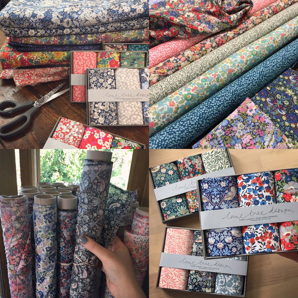 A photo of many rolls of pretty, floral Liberty of London fabric