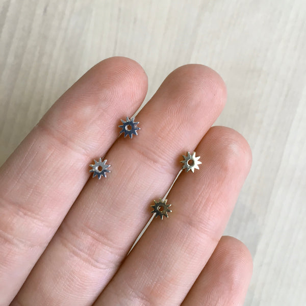 mini flower studs in hand to show size 