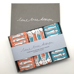 orange and turquoise fish hankies on hand printed fabric in a gift box 