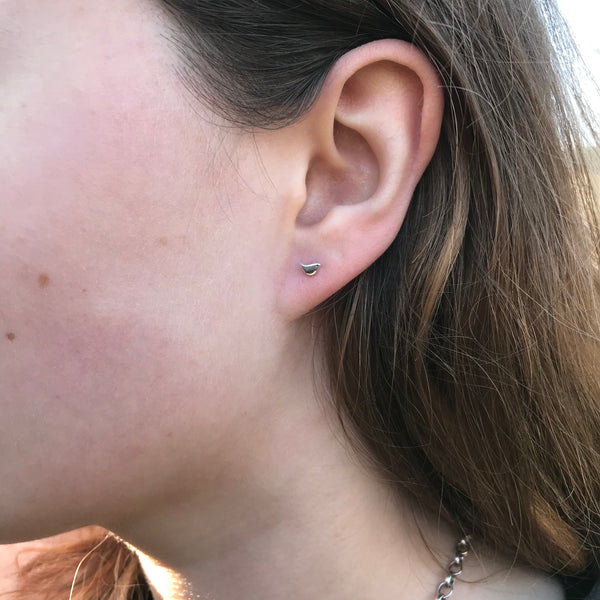 gold bird earrings in ear 