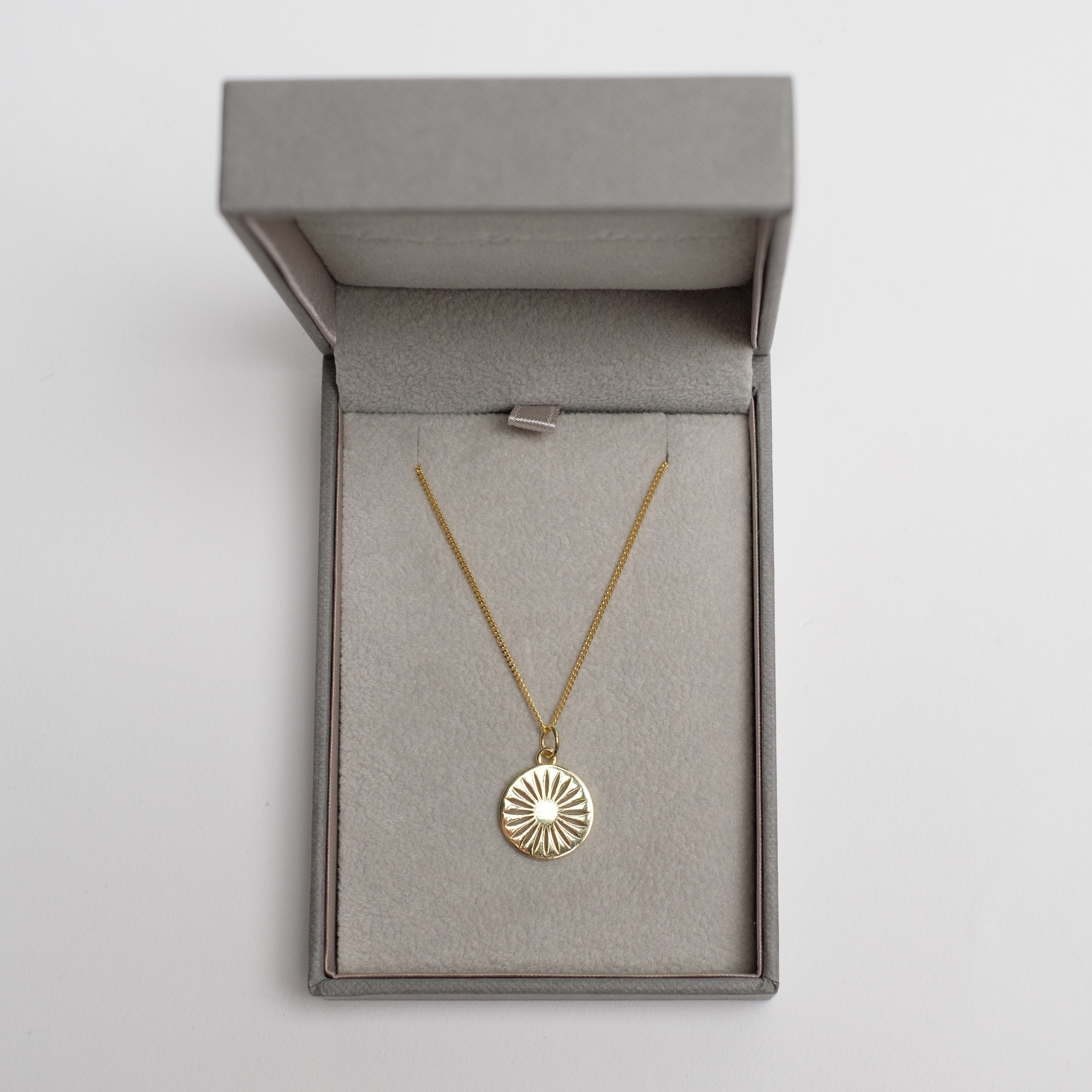 daisy necklace in gold in a box 