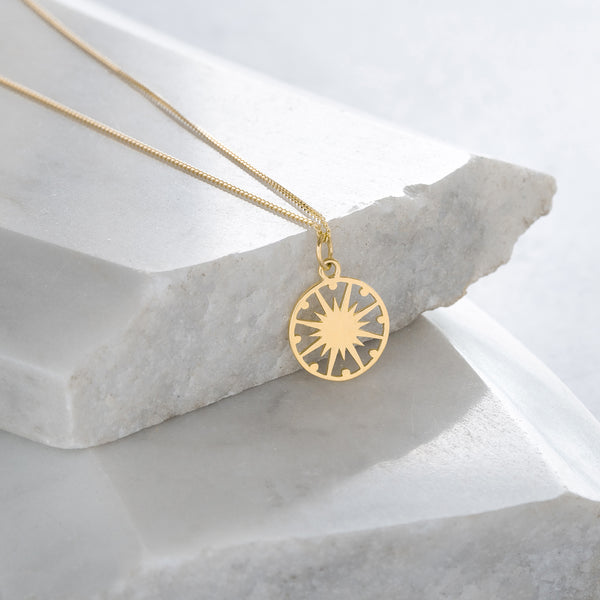 gold vermeil supernova token necklace on marble 