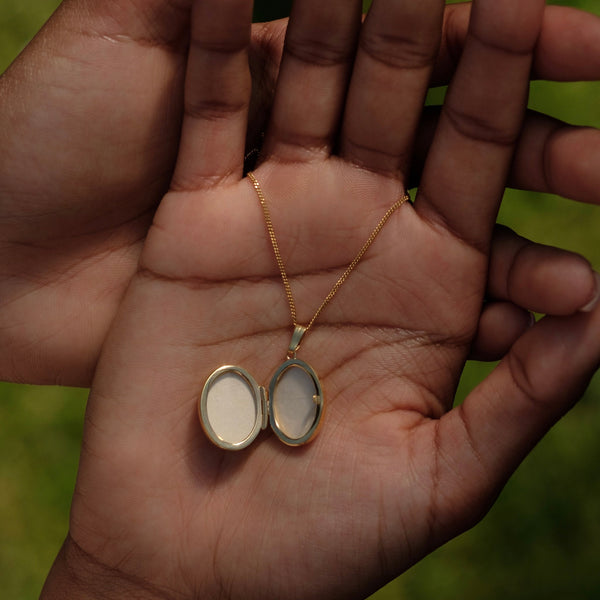 open gold locket in a hand to show size 